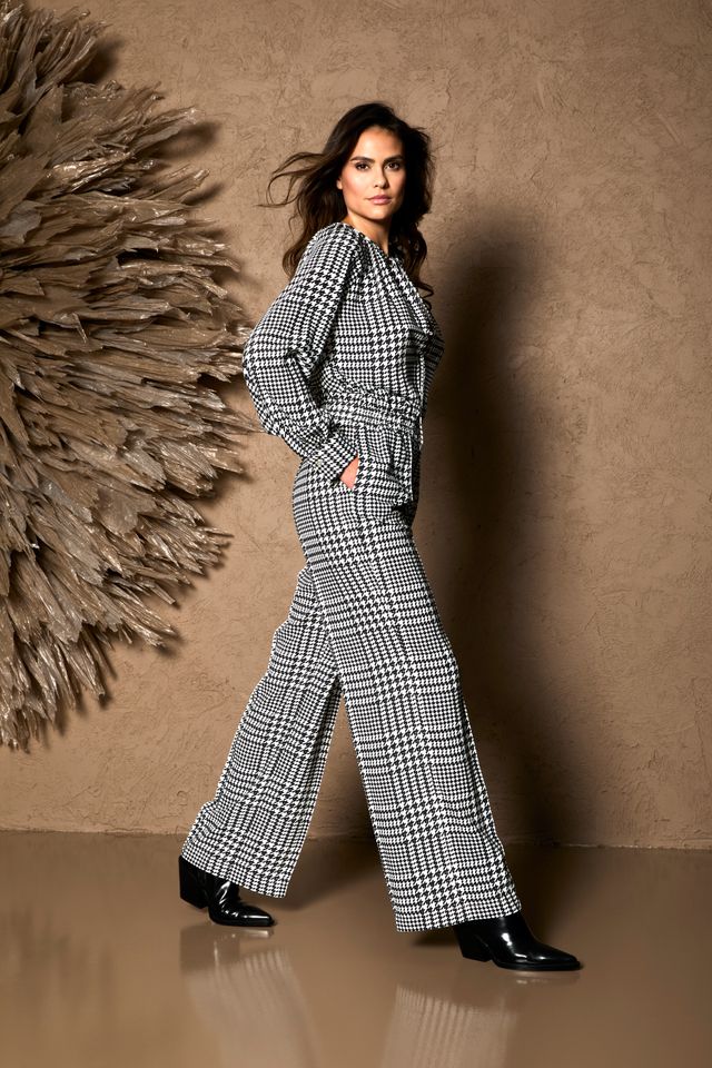 Elegante Frau in hessischem Karojackenanzug mit weiten Hosen und schwarzen Pumps.